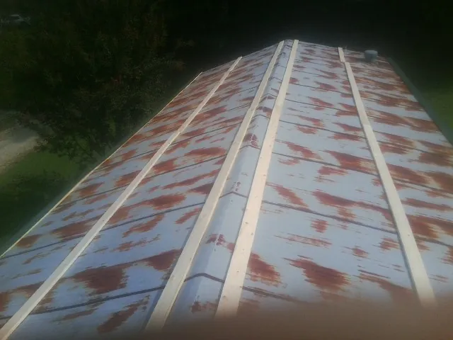 Rusted metal roof panels with new wood purlins before replacement — Storm Damage Roof Repair in Westover by Roofing Brothers