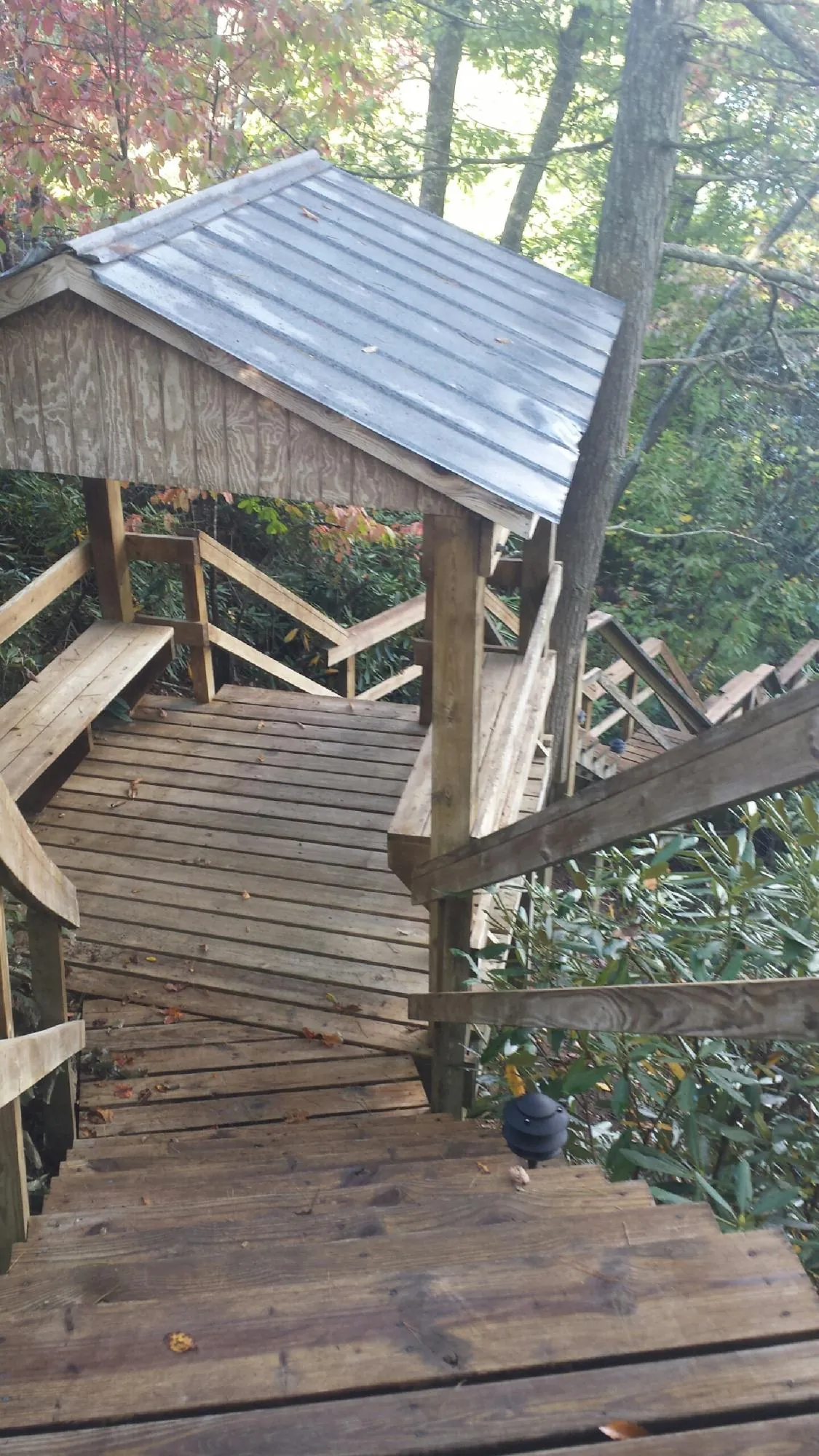 Metal roofed shelter over wooden steps on a wooded walkway — Skylight Repair & Installation work by our crew in Westover