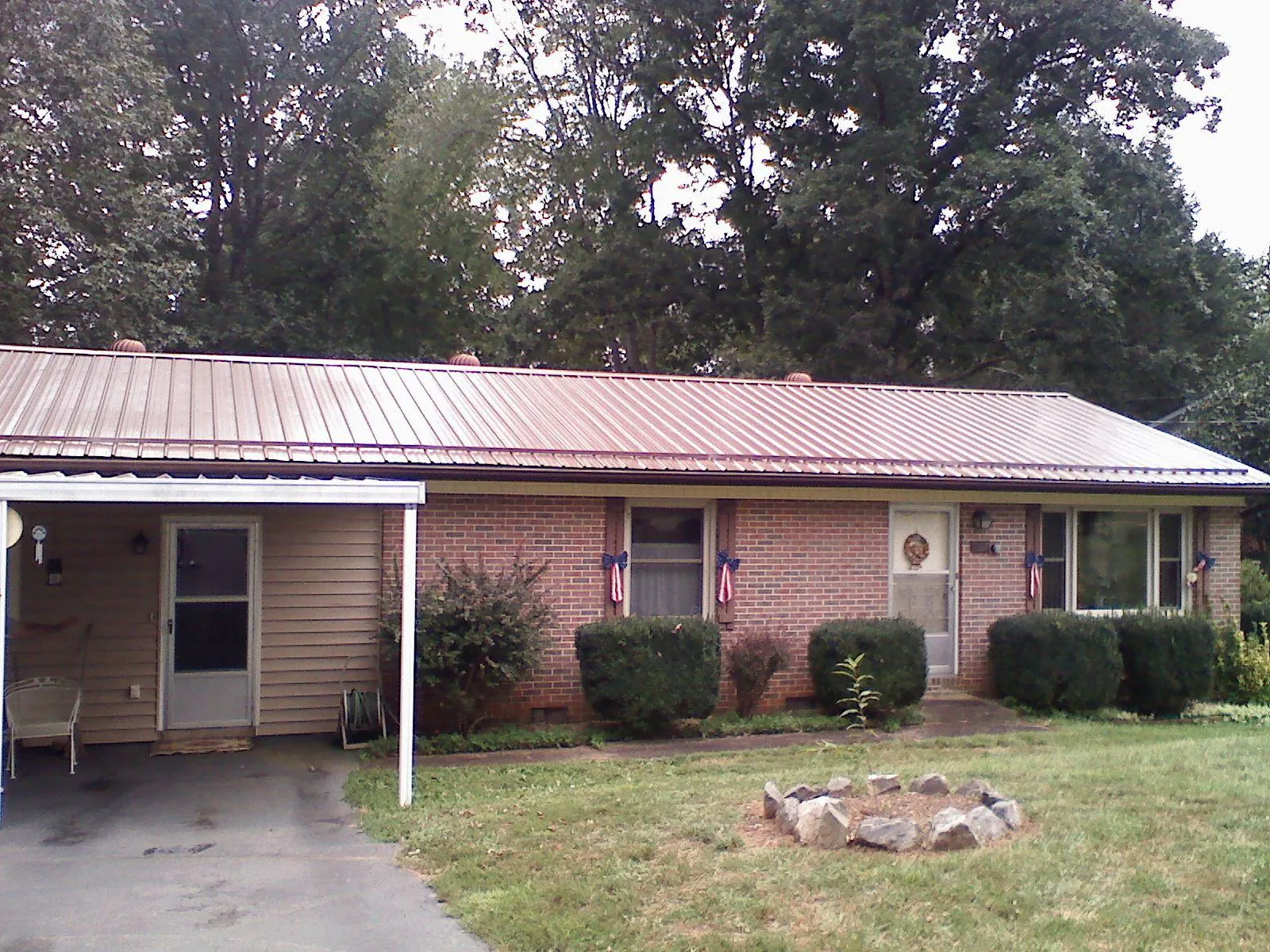 Bronze metal roof and carport on a brick ranch home — Roof Repair work by our crew in Westover